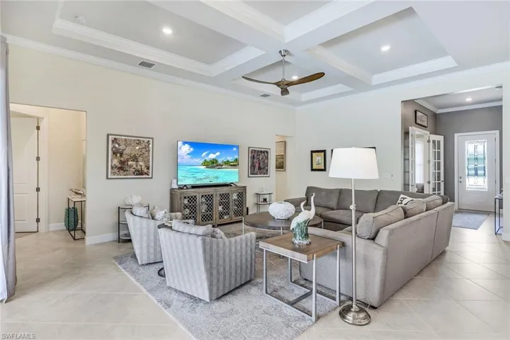 Coffered ceiling, crown molding, a high ceiling, fan, and 2 sided zero corner sliders that open to lanai