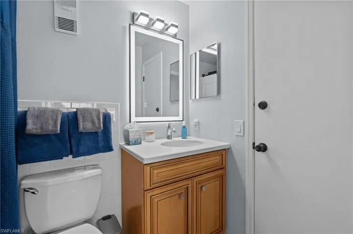 Bathroom with vanity, a shower with curtain, and tile walls