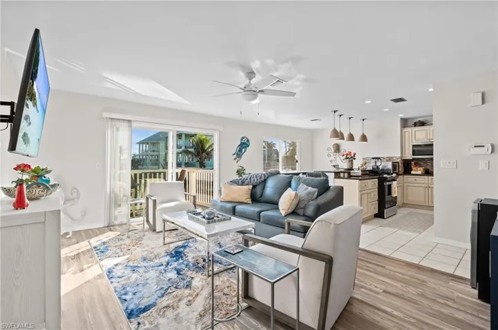 Living area with recessed lighting, light wood-type flooring, and a ceiling fan