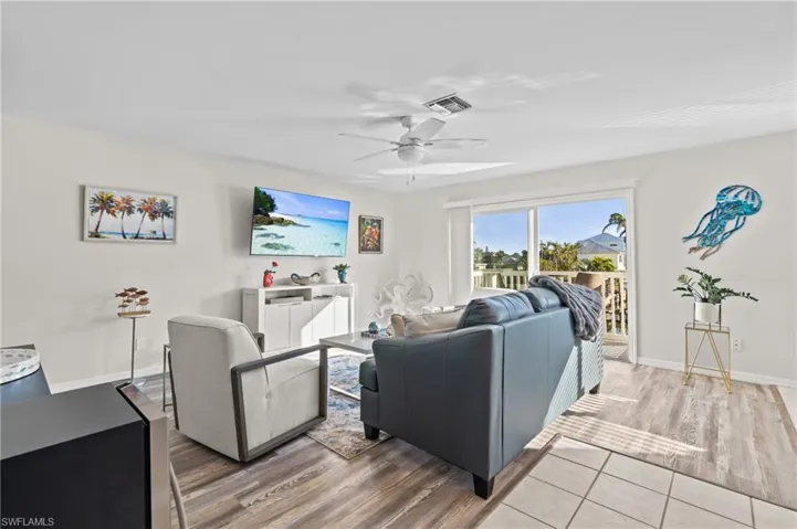 Living area with wood finished floors and ceiling fan