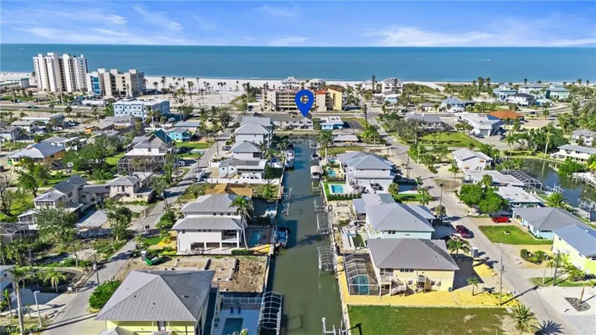 Aerial view of property's location with a nearby body of water and nearby suburban area