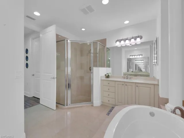 Full bath featuring a shower stall, visible vents, recessed lighting, and vanity