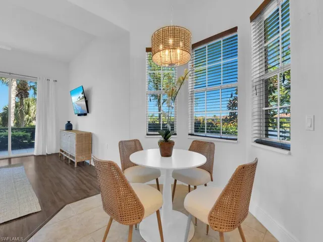Dining area featuring baseboards, an inviting chandelier, tile patterned floors, and plenty of natural light