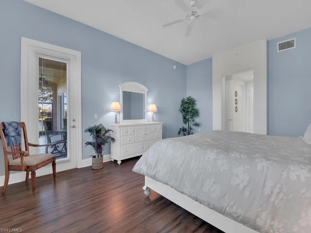 Bedroom with visible vents, baseboards, access to outside, a ceiling fan, and dark wood-type flooring
