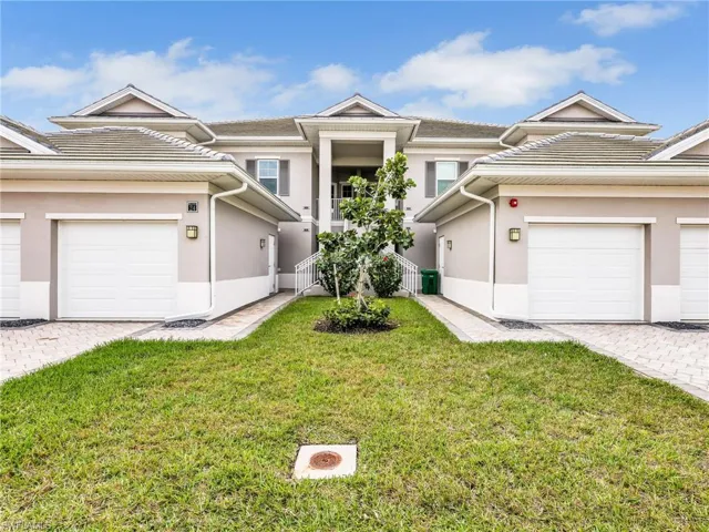 View of front of house featuring stucco siding, a front yard, and decorative driveway