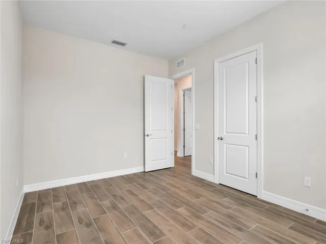 Unfurnished bedroom featuring wood tiled floors and baseboards