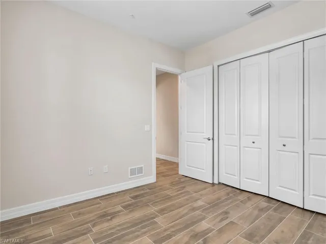 Unfurnished bedroom featuring wood finish floors and a closet