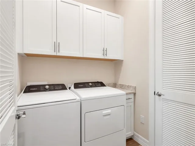 Laundry area featuring independent washer and dryer and cabinet space
