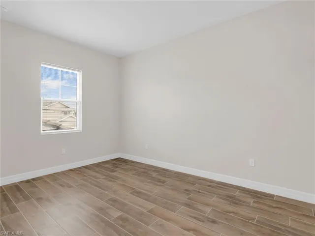 Empty room featuring wood tiled floors and baseboards