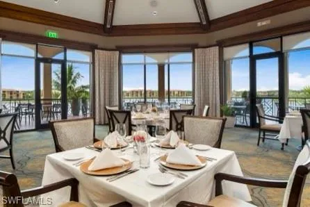 Dining area with beam ceiling, high vaulted ceiling, a water view, and plenty of natural light