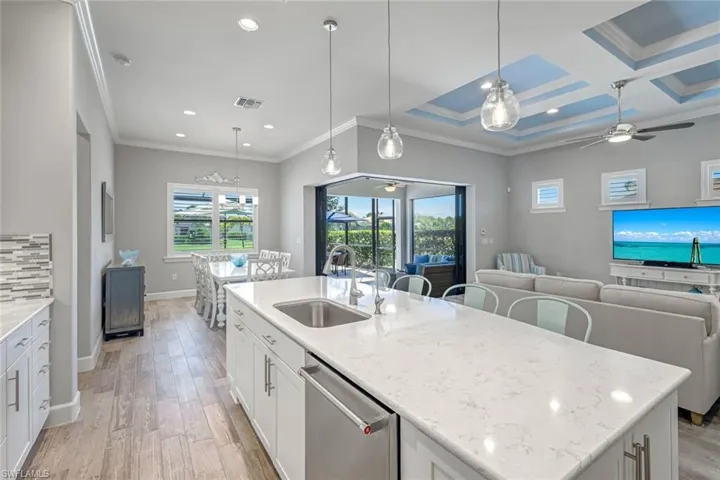 Kitchen with open floor plan, crown molding, a ceiling fan, light wood-style floors, and dishwasher