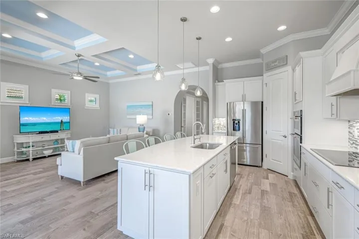 Kitchen featuring arched walkways, tasteful backsplash, ornamental molding, appliances with stainless steel finishes, and recessed lighting