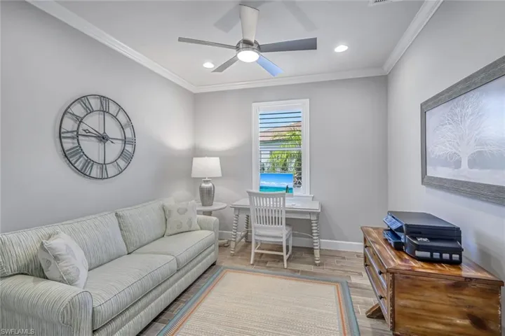 Living area with wood finished floors, crown molding, recessed lighting, and ceiling fan