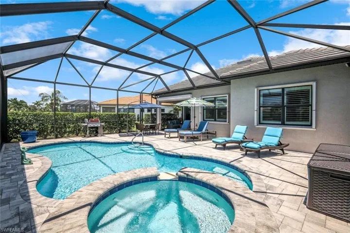 View of pool with a pool with connected hot tub, a patio area, and grilling area