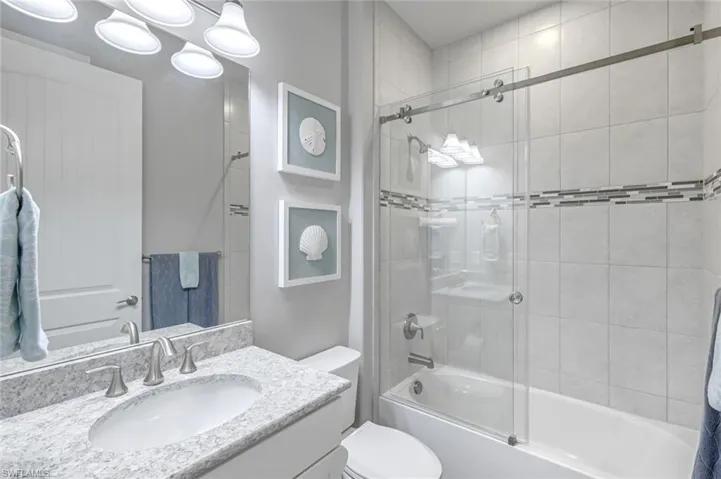 Bathroom featuring vanity and combined bath / shower with glass door