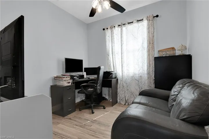 Office with light wood-style flooring and a ceiling fan