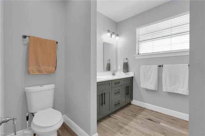 Bathroom featuring double vanity and light wood finished floors
