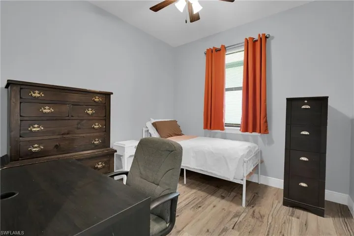 Bedroom featuring wood finished floors, ceiling fan, and lofted ceiling