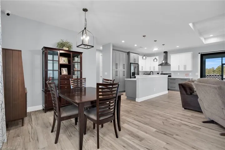 Dining space with light wood finished floors and recessed lighting