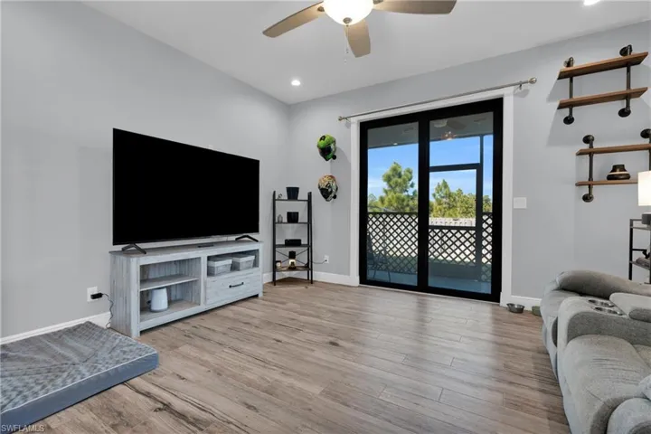 Living area featuring light wood-style floors, a ceiling fan, and recessed lighting