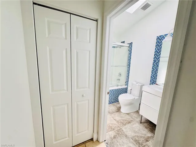 Bathroom featuring bathtub / shower combination, a closet, and vanity
