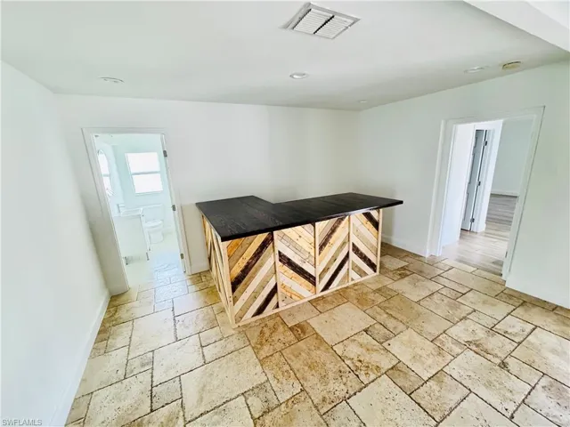 Unfurnished dining area featuring stone tile floors and recessed lighting