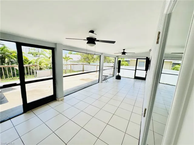 Unfurnished sunroom with a ceiling fan and healthy amount of natural light