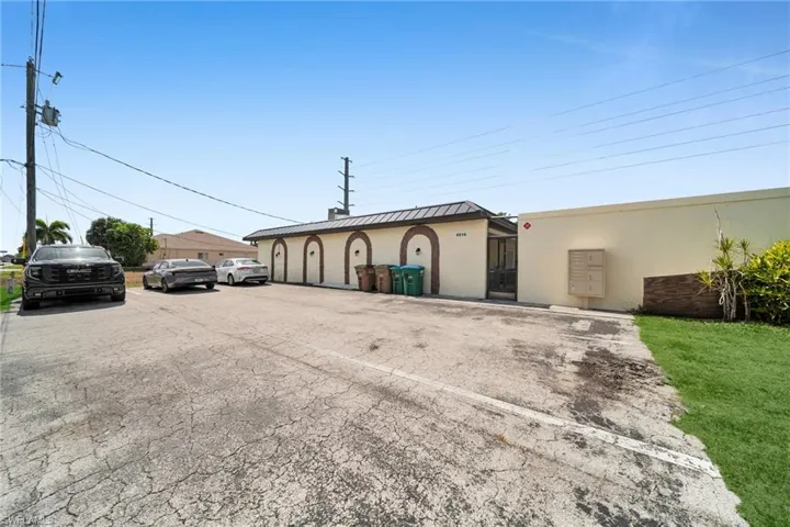 View of building exterior featuring uncovered parking