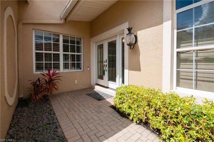 Property entrance with stucco siding and french doors