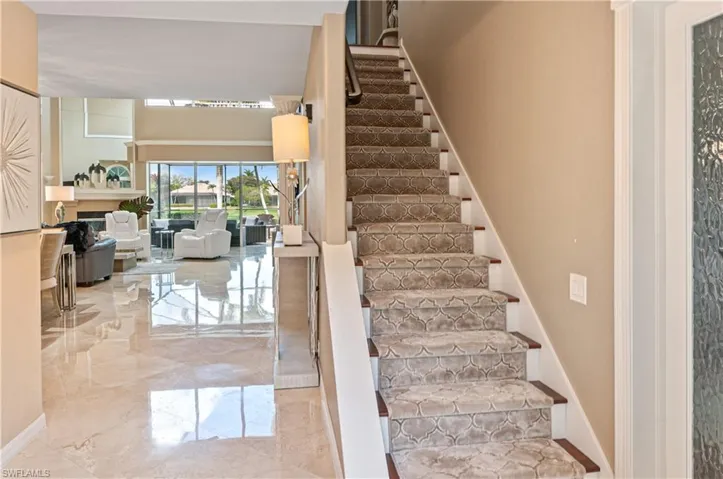 Staircase with marble tiled flooring and a fireplace