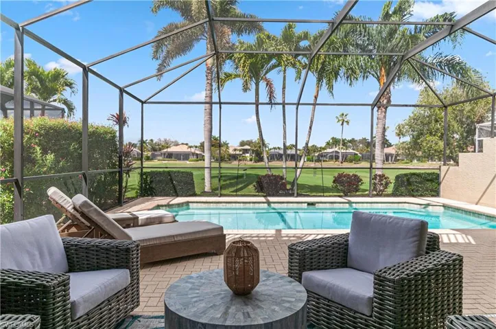 Swimming pool with a sunroom, a lanai, a patio, and a residential view