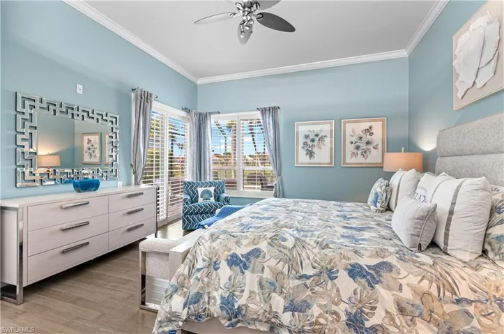 Bedroom with ornamental molding, light wood finished floors, and ceiling fan