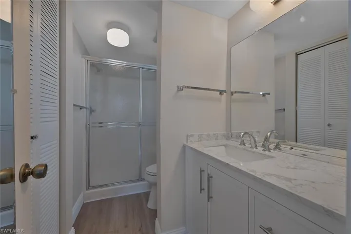 Bathroom with a closet, vanity, and a shower stall