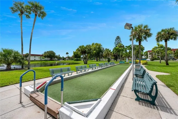 View of home's community featuring a yard, a bocce ball area, and a water view