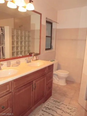Double vanity with wood-finish cabinetry and light-toned countertop