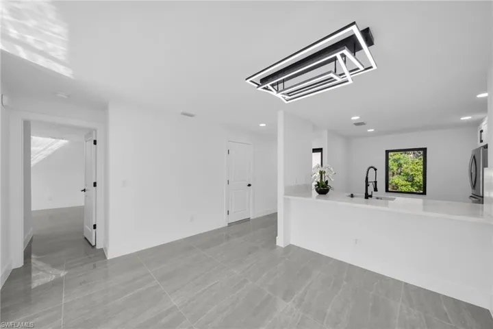 Unfurnished living room featuring a sink and recessed lighting