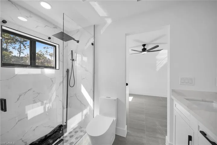Full bathroom featuring vanity and a marble finish shower