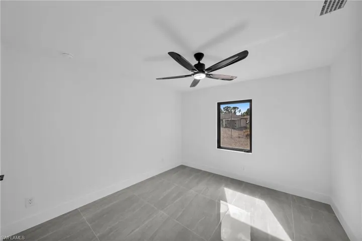 Unfurnished room featuring baseboards and ceiling fan