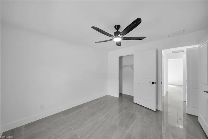 Unfurnished bedroom featuring a ceiling fan and a closet