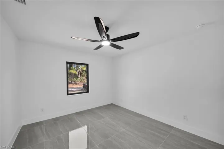 Unfurnished room featuring baseboards and ceiling fan