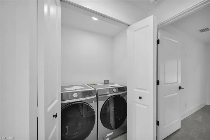 Laundry area with separate washer and dryer and baseboards