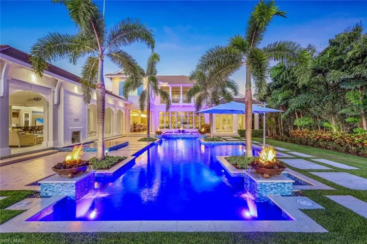 View of pool featuring a patio area, a storage structure, an outdoor fire pit, and a pool with connected hot tub