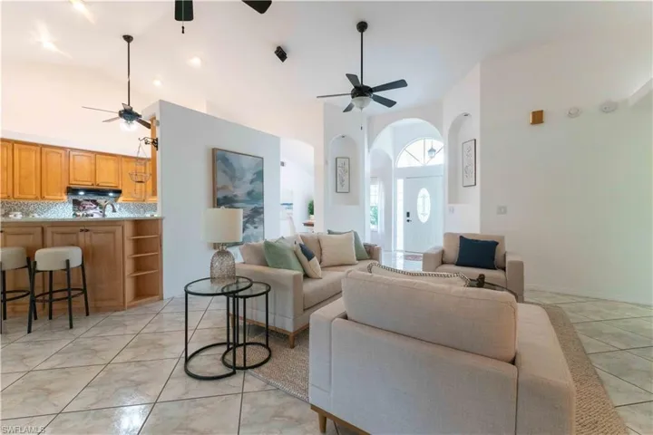 Living room featuring ceiling fan and a towering ceiling
