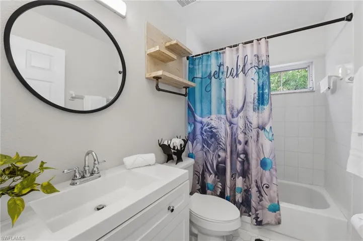 Full bath with shower / bath combo with shower curtain and vanity