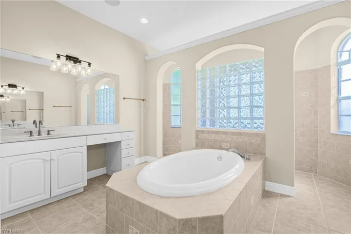 Full bath featuring a bath, vanity, healthy amount of natural light, light tile patterned flooring, and recessed lighting
