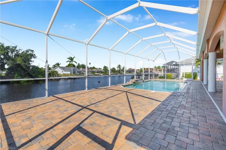 Outdoor pool with a sunroom, a patio, a lanai, and a water view