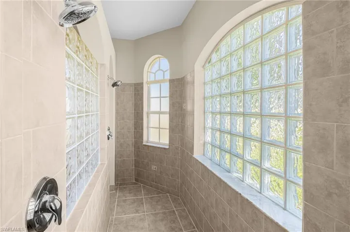 Bathroom with a tile shower and tile patterned flooring