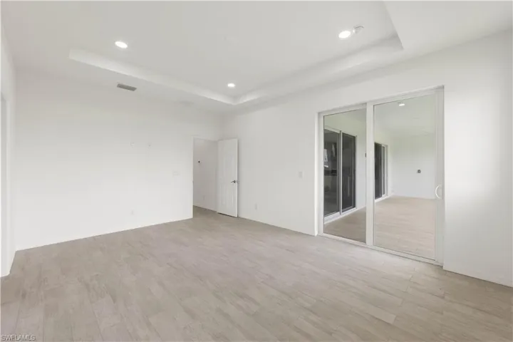 Spare room with light wood-type flooring and a tray ceiling