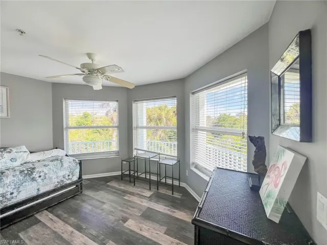 Bedroom with ceiling fan, baseboards, and dark wood-type flooring