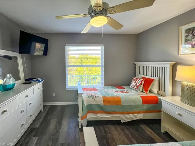Bedroom with dark wood-style flooring, a ceiling fan, and baseboards